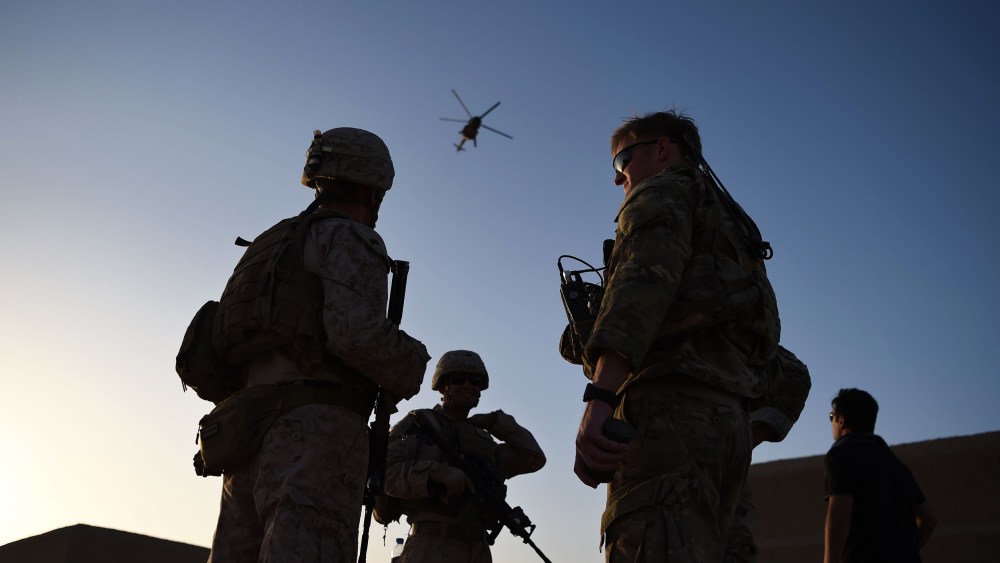 U.S. Marines and Afghan Commandos stand together as an Afghan Air Force helicopter flies past during a combat training exercise at Shorab Military Camp in Lashkar Gah in Helmand province, Afghanistan, on Aug. 27, 2017.