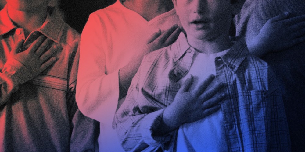 Image of students with hands over their hearts reciting the pledge of allegiance.