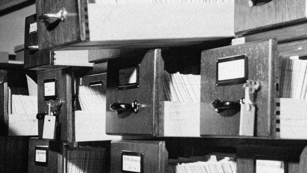 Image of stacks of open filing cabinets with papers.