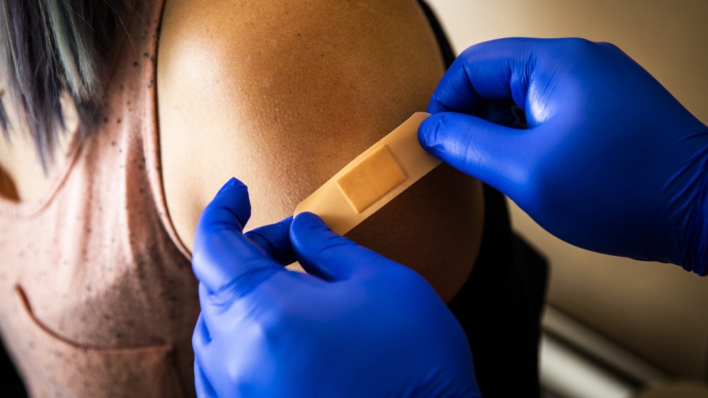 Image: A healthcare worker places a band-aid on a patient after administering a dose of the Pfizer-BioNTech Covid-19 vaccine at Boston Medical Center on June 17, 2021.