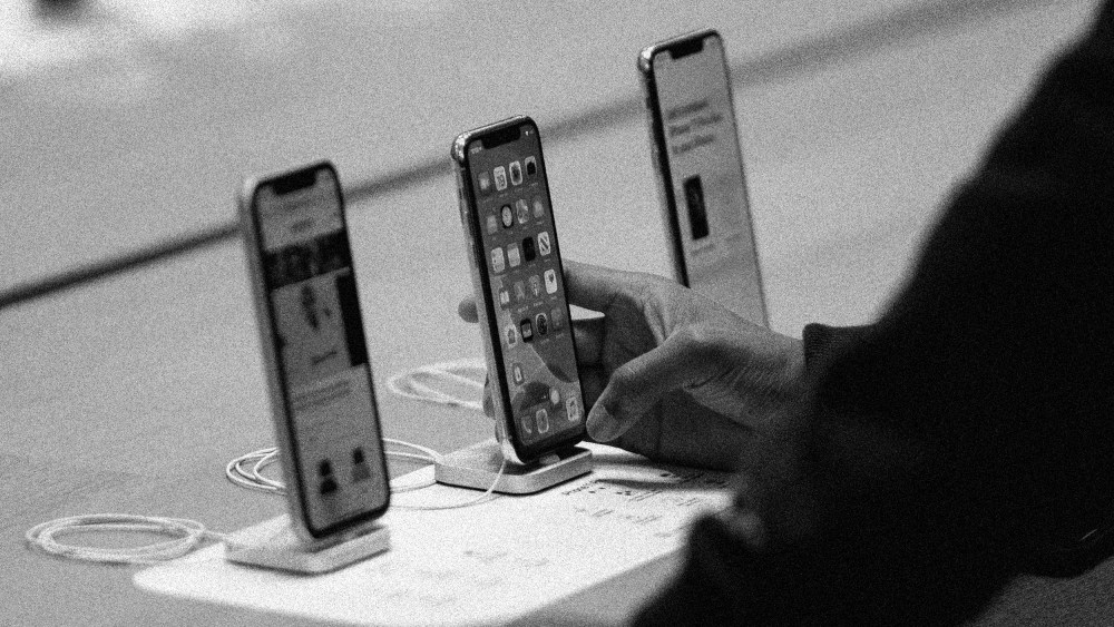 Image: Customer holding an iPhone 11 at an Apple Store.