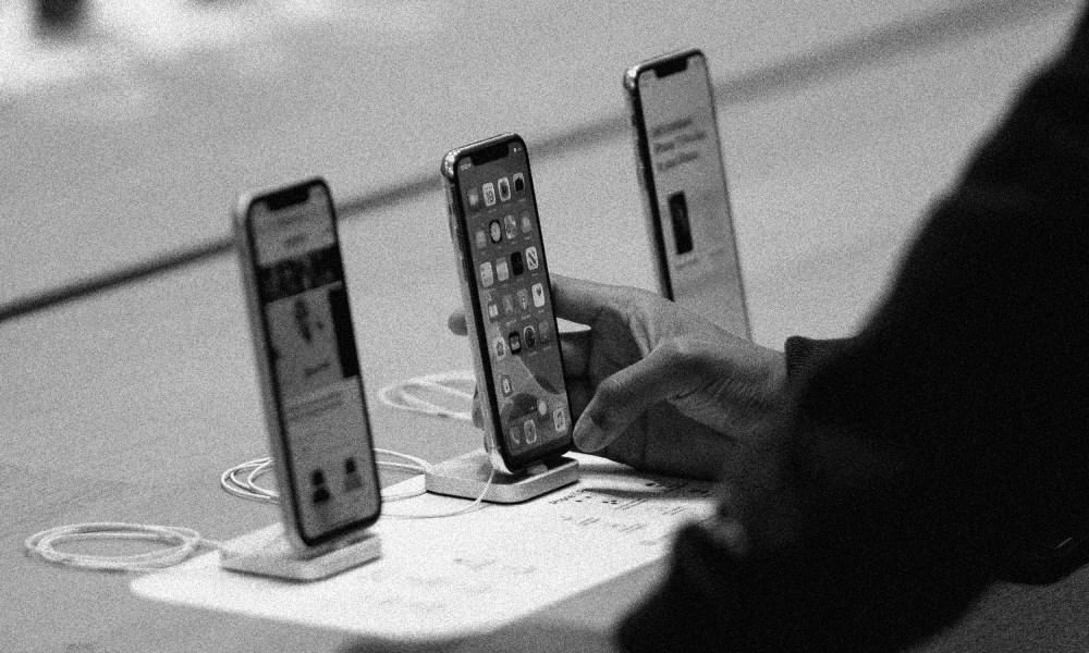 Image: Customer holding an iPhone 11 at an Apple Store.