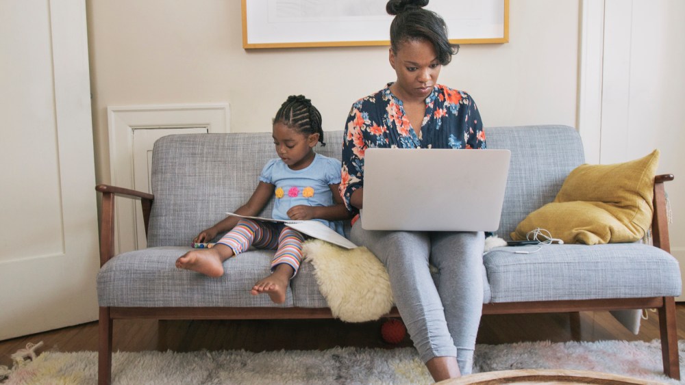 African American mother and daughter relaxing in living room