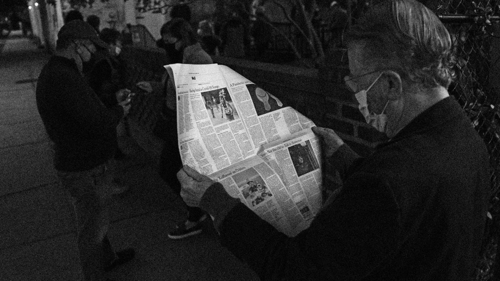 Image: John Winthrop reads a newspaper as he waits to vote in Charleston, S.C., on Nov. 3, 2020.