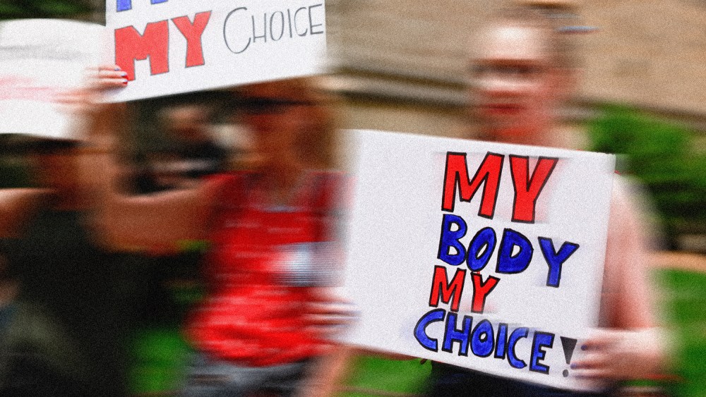 Image: A protestor holding a placard that reads,"MY BODY MY CHOICE!"