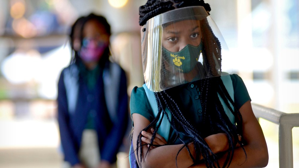 Victoria Dickens wears a mask and face shield as she waits for her class assignment at Summit Elementary School in Summit, Miss., on Aug. 5, 2021