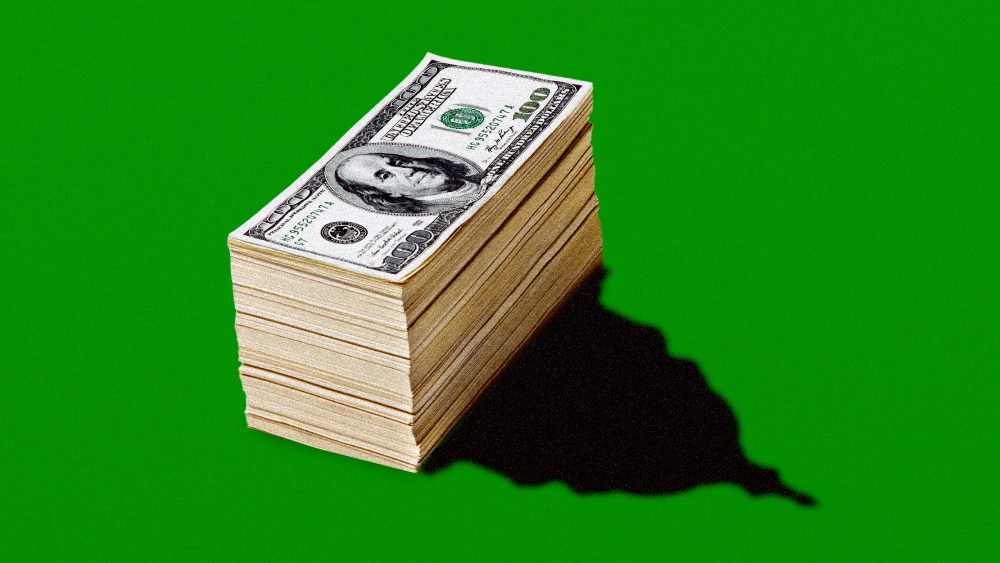 Photo illustration: A pile of money has a reflection in the shape of the US Capitol dome.
