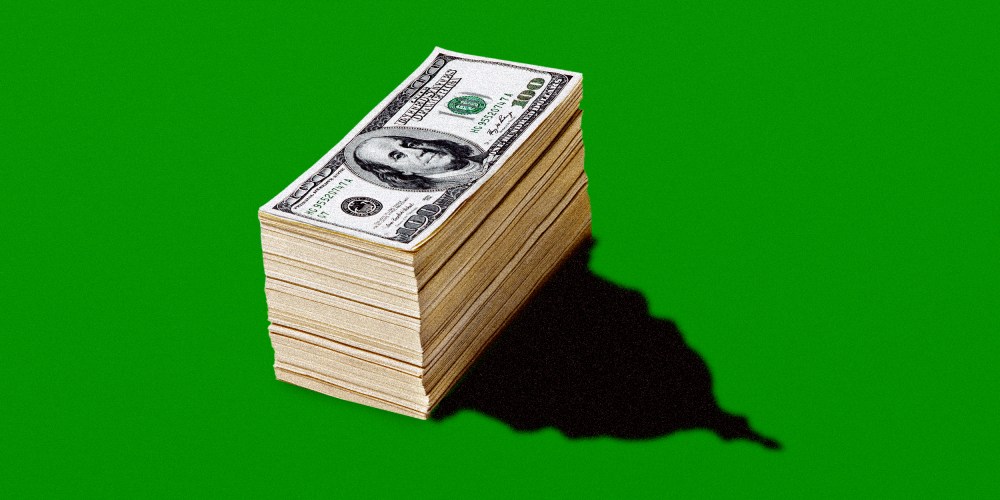 Photo illustration: A pile of money has a reflection in the shape of the US Capitol dome.