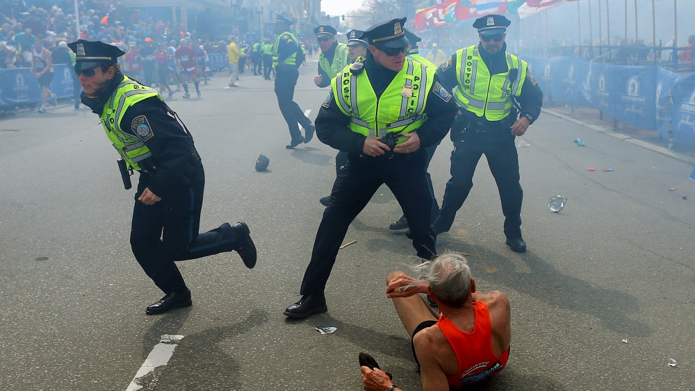 Image: Police officers draw their guns as a second explosion occurs during the Boston Marathon on April 15, 2013.