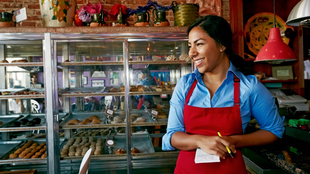 Hispanic waitress taking orders in bakery
