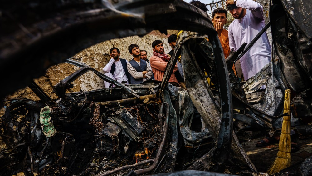Image: Residents gather around an incinerated car that was hit by a U.S. drone strike in Kabul, Afghanistan, on Aug. 30, 2021.