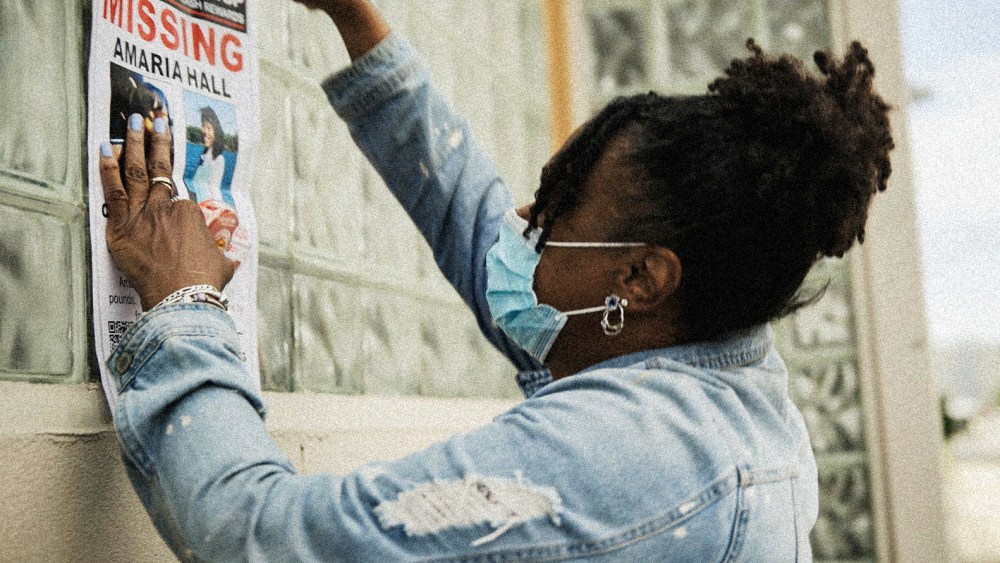 Image: A community member posts a missing poster of Amaria Hall.
