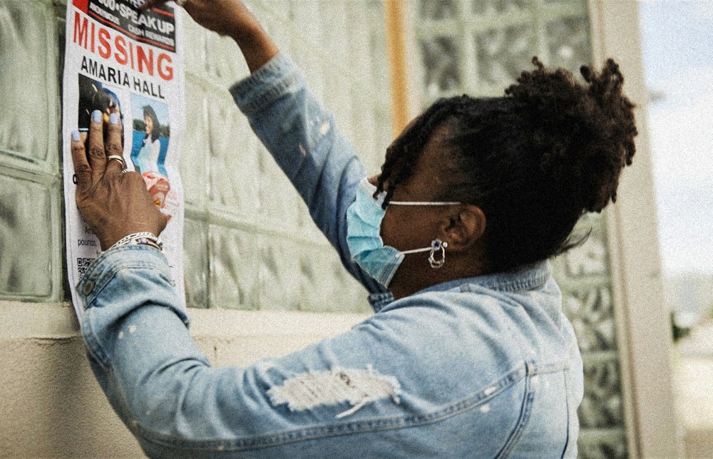 Image: A community member posts a missing poster of Amaria Hall.