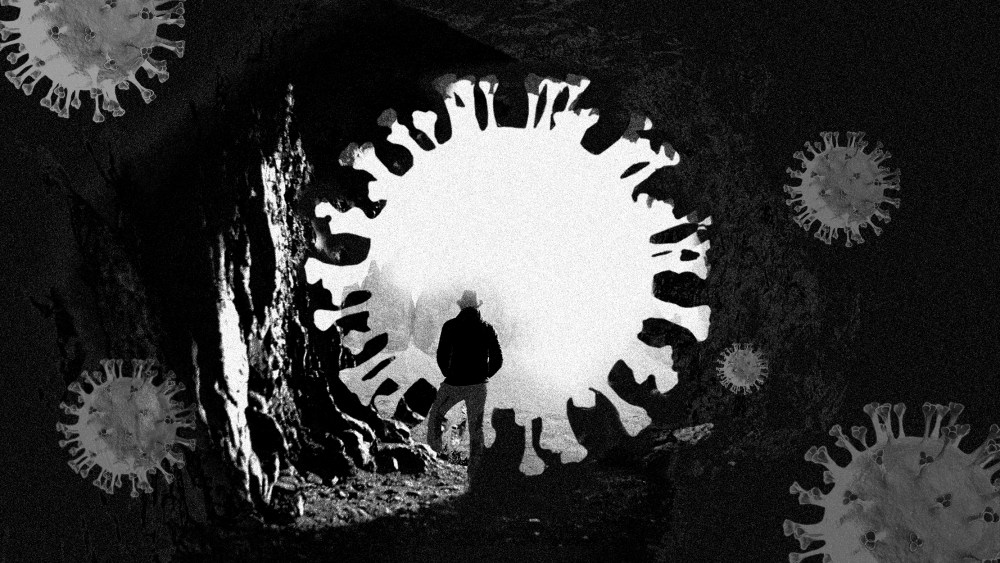 Photo illustration: A person standing at a Covid particle shaped opening of a dark cave.