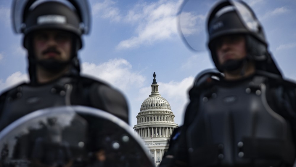 Image: Two officers stand guard with the U.S. Capitol in the background.