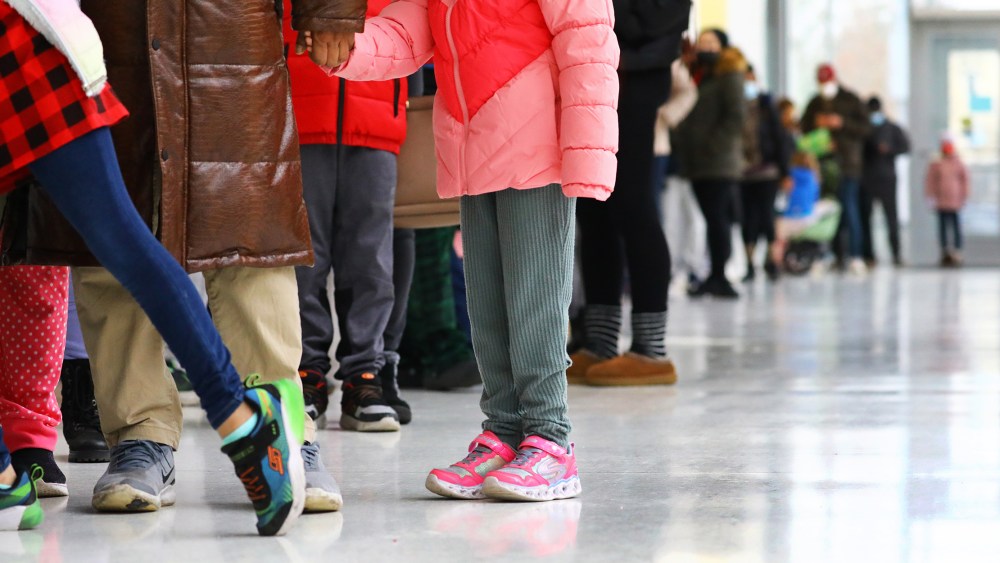 Image: Children stand in line to get tested for Covid-19.