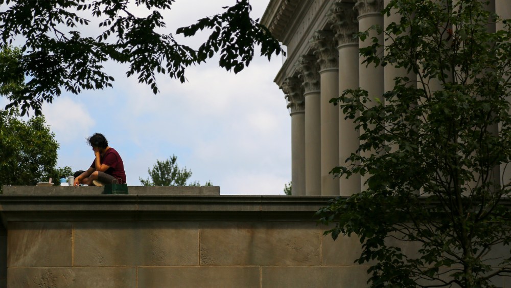 Image: A student sitting a reading on the Harvard University campus.
