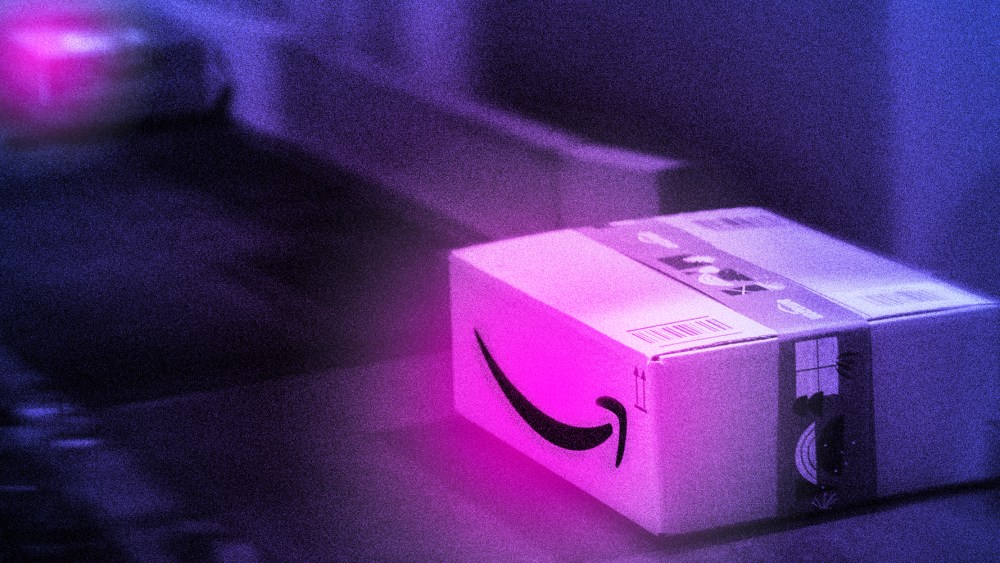 Photo illustration: A conveyor belt carrying glowing packages with the Amazon logo.