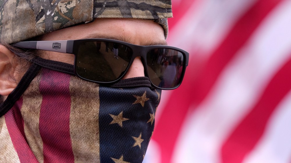 Image: An anti-vaccination protester wearing a face mask with American flag takes part in a rally against Covid-19 vaccine mandates.