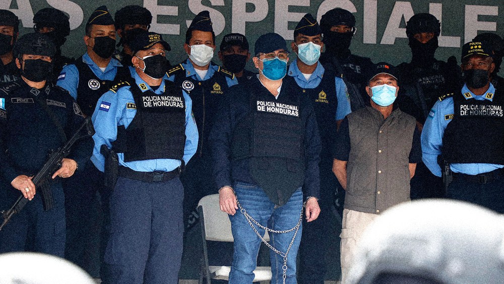 Image: Former Honduran President Juan Orlando Hernandez, center in chains, at the Police Headquarters in Tegucigalpa, Honduras.