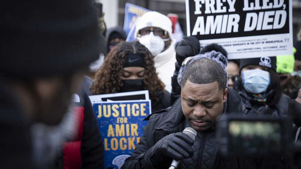 Image: Andre Locke, father of Amir Locke speaking to a crowd holding signs that read,"Frey lied Amir died" and "Justice for Amir Locke".