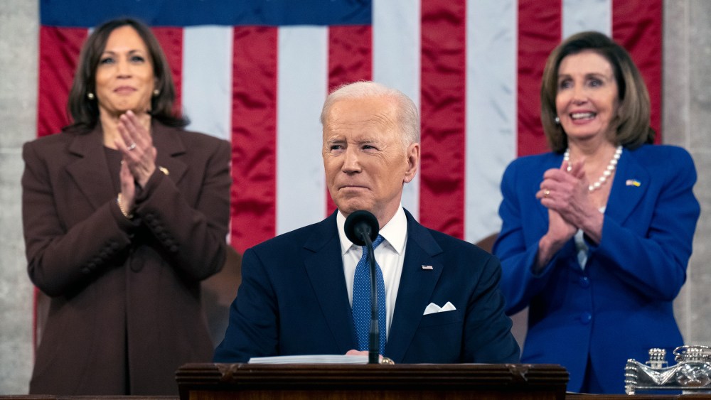 Image: Kamala Harris and Nancy Pelosi applauding in the background as Joe Biden delivers his State of the Union address.