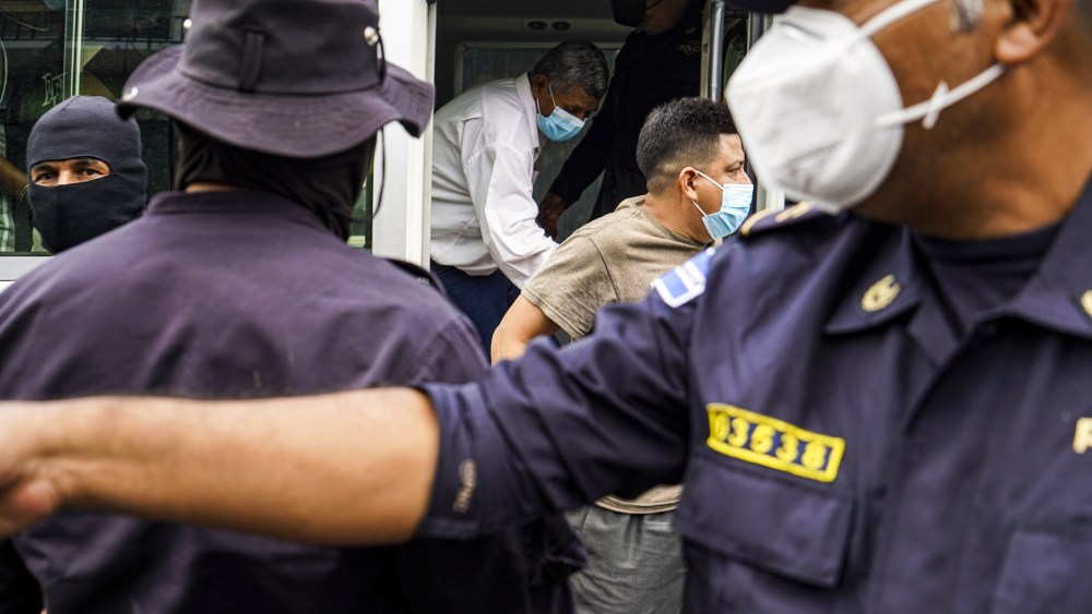 IMage: Alleged gang members are brought to a detention center in San Salvador, El Salvador, on March 29, 2022.