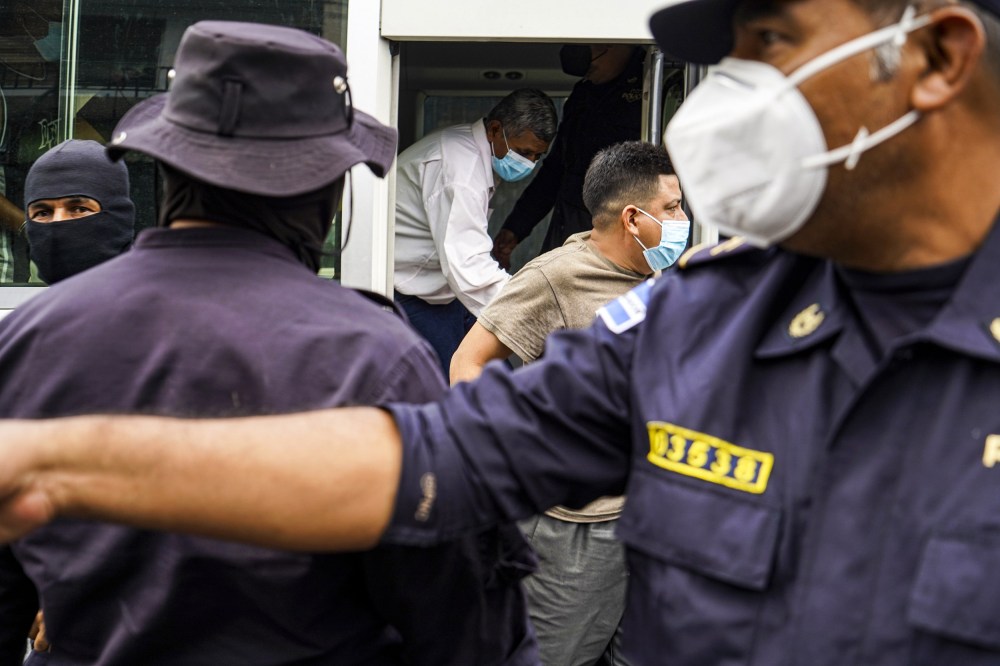 IMage: Alleged gang members are brought to a detention center in San Salvador, El Salvador, on March 29, 2022.