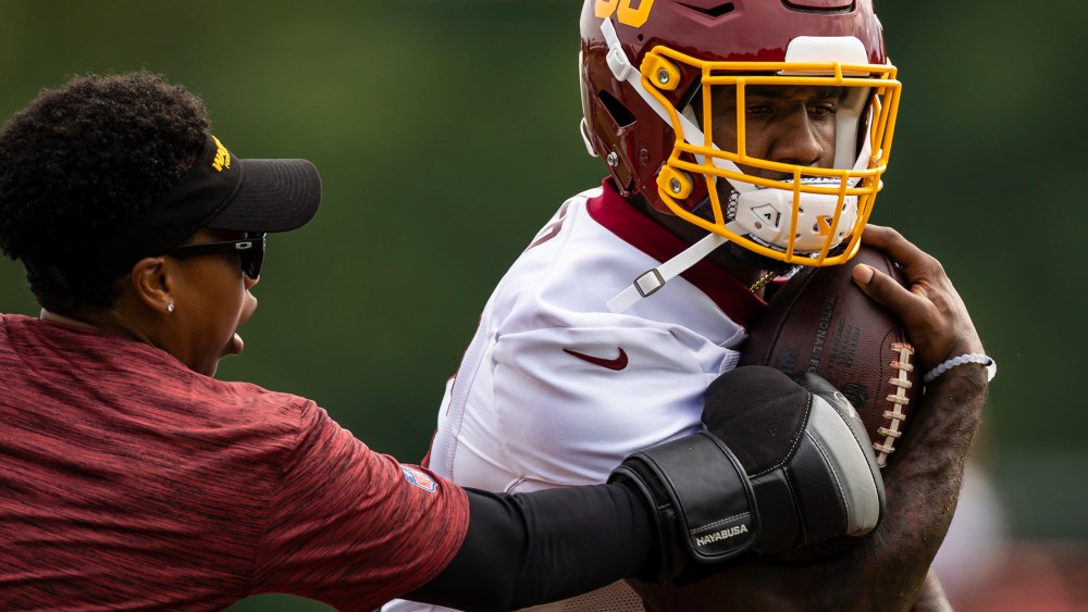 Image: Lamar Miller of the Washington Football Team participates in a drill with assistant running backs coach Jennifer King.