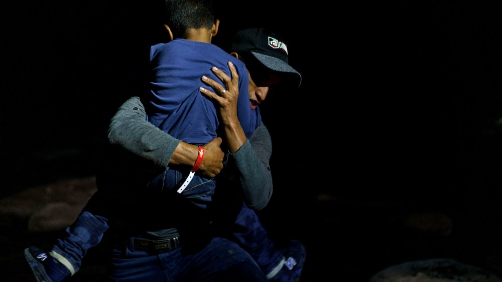 Image: Honduran migrant Eric Villanueva carries his son, Eric, 7, onto the shore of the Rio Grande after crossing the border into the United States from Mexico on July 9, 2021.