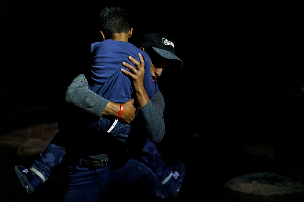 Image: Honduran migrant Eric Villanueva carries his son, Eric, 7, onto the shore of the Rio Grande after crossing the border into the United States from Mexico on July 9, 2021.