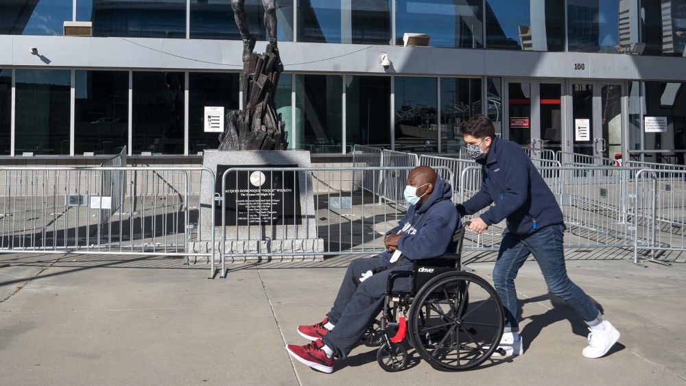Image: A voter on a wheelchair being assisted during early voting for the Georgia runoff elections at the State Farm Arena in Atlanta, Georgia.