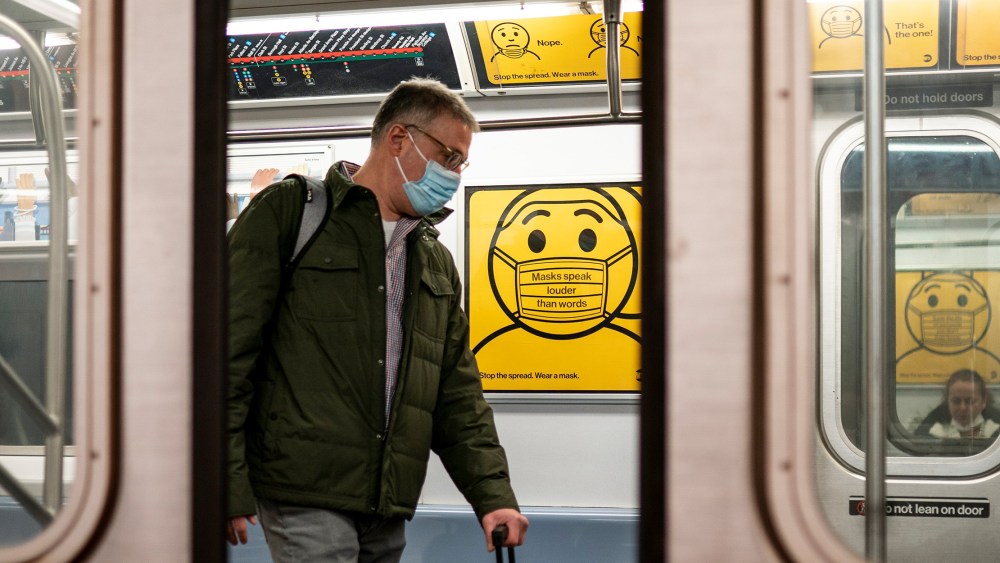 Image: Mass transit rider wearing a mask as they commute on the New York Subway.