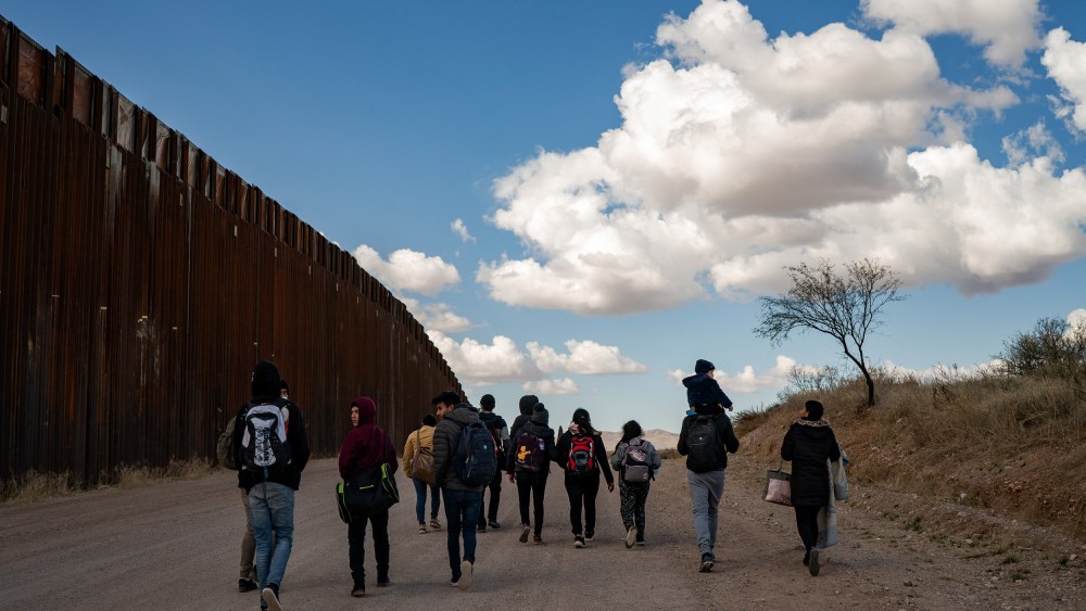 IMage: A group of migrant families from Central America walk near the border wall between the United States and Mexico near Sasabe, Ariz., on Jan. 23, 2022.