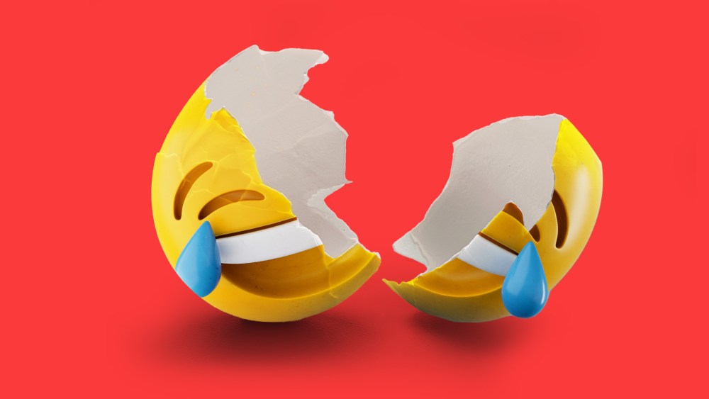 Photo illustration: A laughing emoji as shell broken into to two parts.