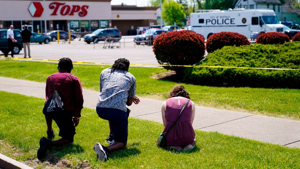 Image: Mourners kneel at the scene of a mass shooting that left 10 dead in Buffalo, N.Y., on May 15, 2022.