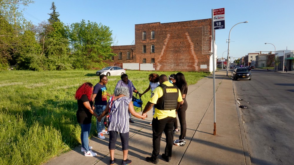 Image: People pray across the street from the Tops supermarket where 10 people were killed in a mass shooting in Buffalo, N.Y., on May 15, 2022.