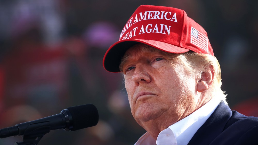 Image: Donald Trump wearing a red hat that reads, "Make America Great Again".