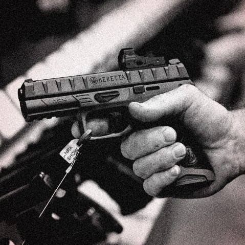 Image: Close-up of a hand holding a gun.