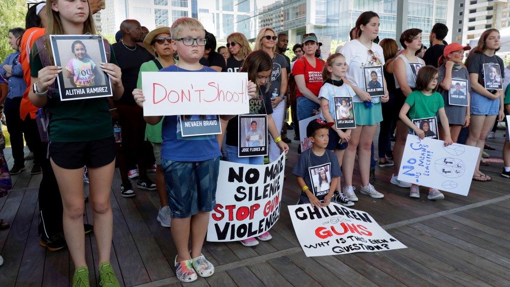 Children hold signs and photos of the Uvalde, Texas school shooting victims