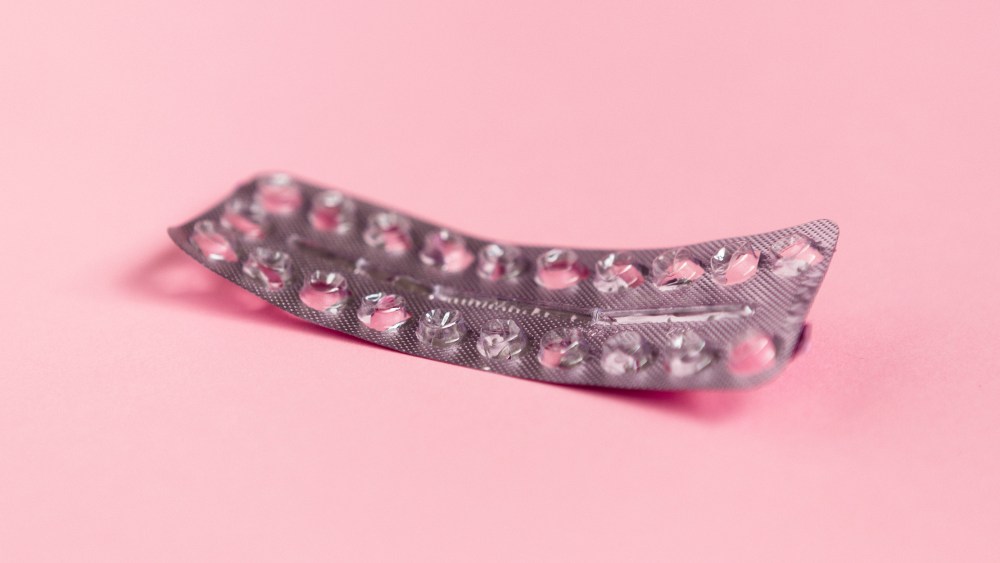 Image: Empty strip of birth control pills on a pink background.