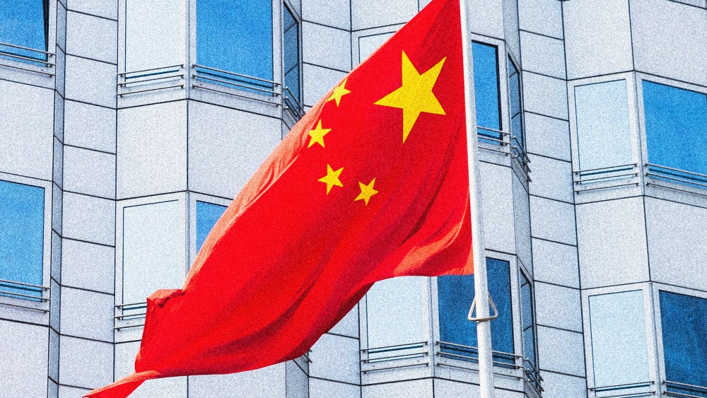Image: The Chinese flag flying outside a building.