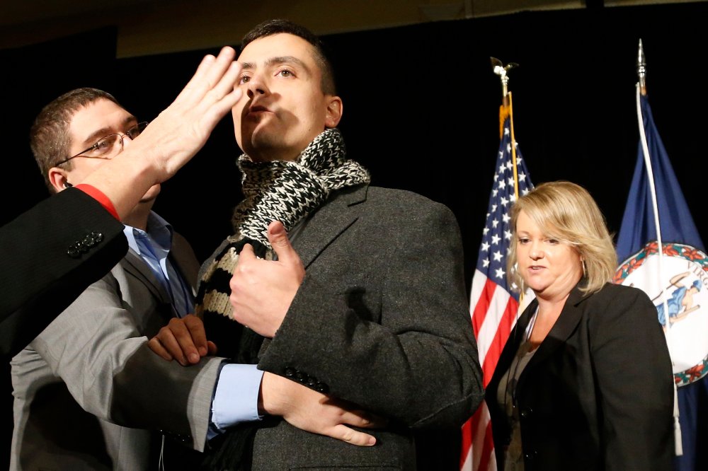 A protester calling for immigration reform is removed from the stage at the election night event for Virginia Republican gubernatorial nominee Ken Cuccinelli in Richmond, Virginia, November 5, 2013.