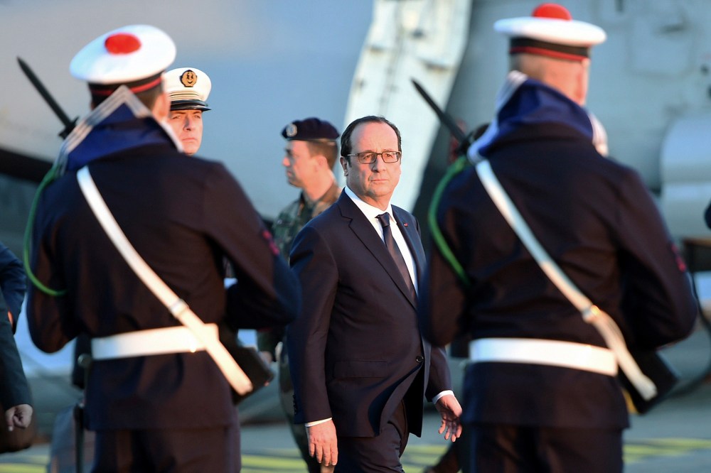 French President Francois Hollande reviews troops during his visit aboard the a French nuclear aircraft carrier on Jan. 14, 2015 off the coast of Toulon, southern France.