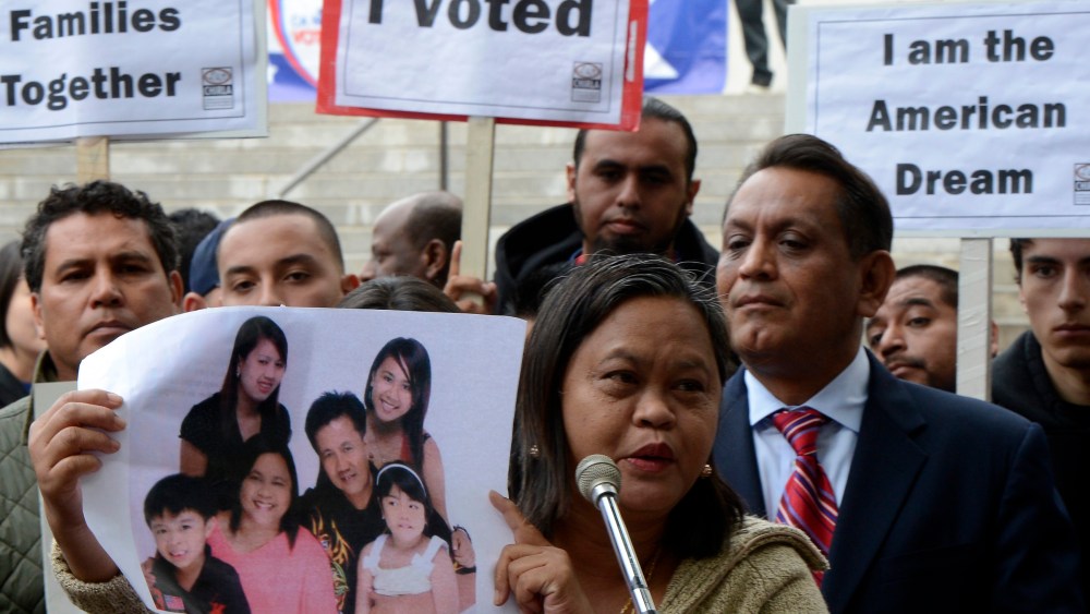 Lolita from the Philippines holds a photograph of her family as she joined other immigrants who gathered in front of Los Angeles City Hall to press for immigration reform following the re-election of US President Barack Obama in Los Angeles, California...