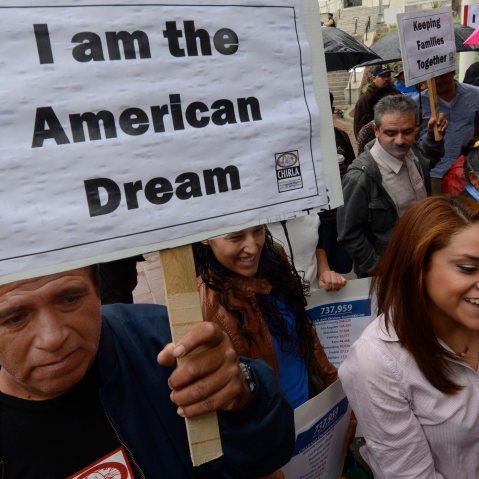 A man holds a poster that reads "I am the American Dream" as he as he joined other immigrants who gathered in front of L.A. City Hall on Nov. 8, 2012. (Photo by Michael Nelson/EPA)