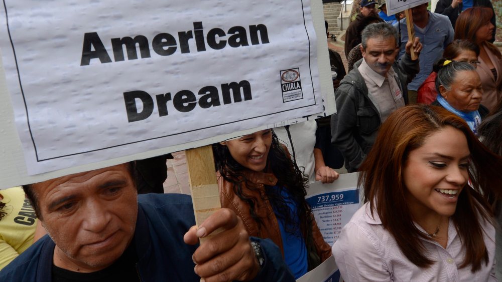 A man holds a poster that reads "I am the American Dream" as he as he joined other immigrants who gathered in front of L.A. City Hall on Nov. 8, 2012. (Photo by Michael Nelson/EPA)