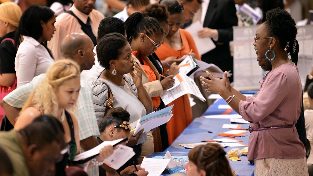 People talking with prospective employers during a job fair at a community center in New York, NY, August 15, 2012.