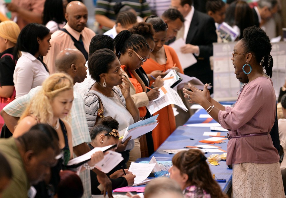 People talking with prospective employers during a job fair at a community center in New York, NY, August 15, 2012.