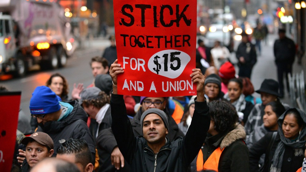 A protester holds up a placard as fast food workers and union members demonstrate in New York City, December 5, 2013.